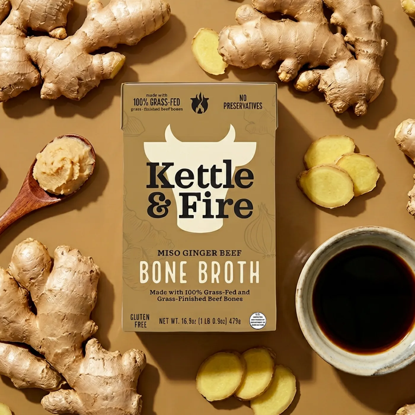Miso Ginger Beef Bone Broth carton among fresh ginger and miso