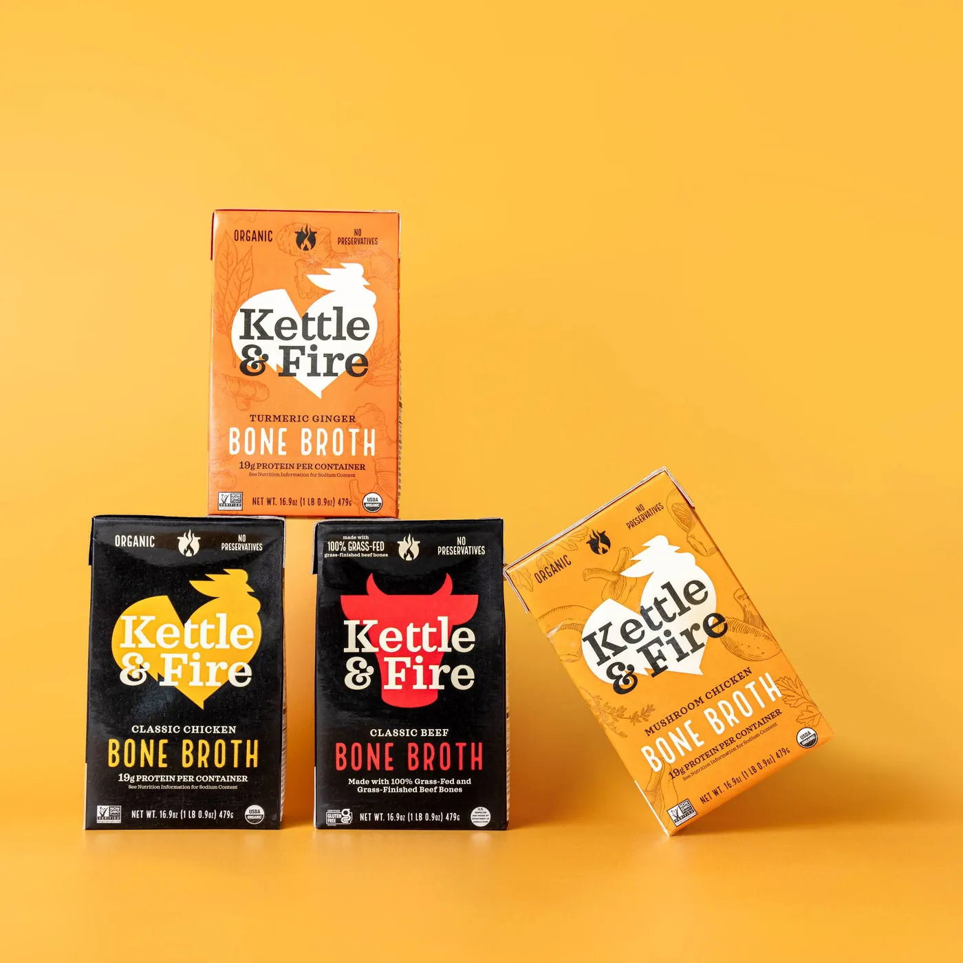 A stack of Kettle & Fire bone broth cartons on a yellow background